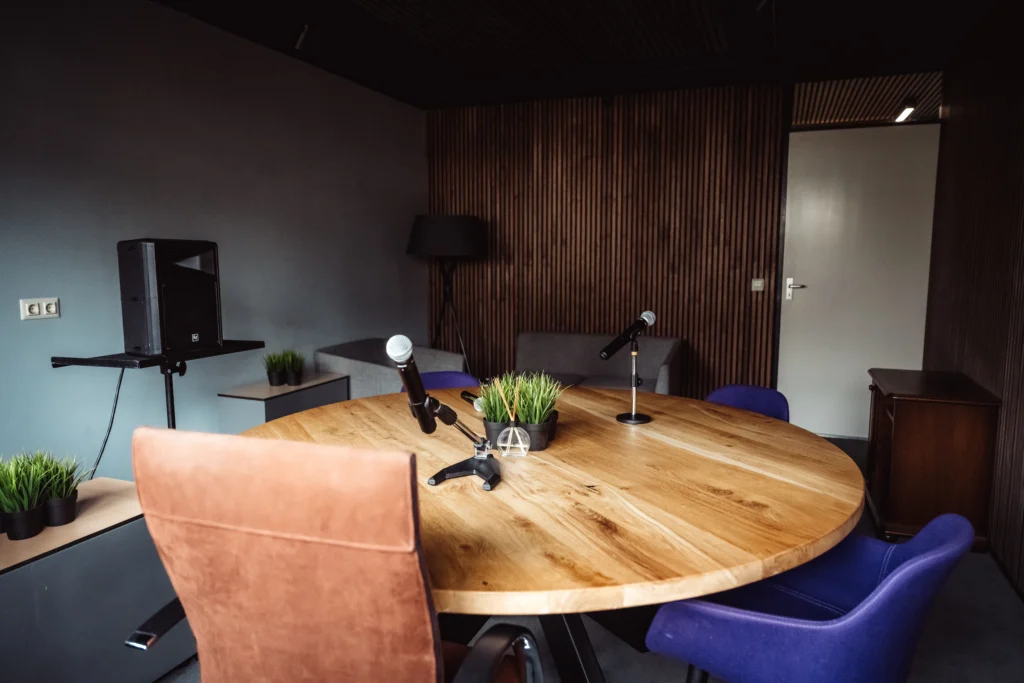 Tafel en stoelen met microfoon, geluidsinstallatie en camera's